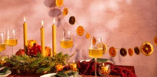 A table scape with earthy decor, candles, and wine glasses.