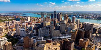 Drone aerial photo of downtown Detroit, Michigan with skyscrapers and the Detroit River on a sunny day.