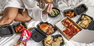 A spread of food on a hotel room bed