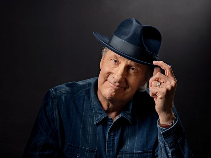 Jeff Daniels posing for a portrait, while wearing a fedora.