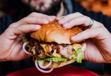 Detroit Burger Week: 5 Things You Must Know Before Dining Young man eating a cheeseburger.