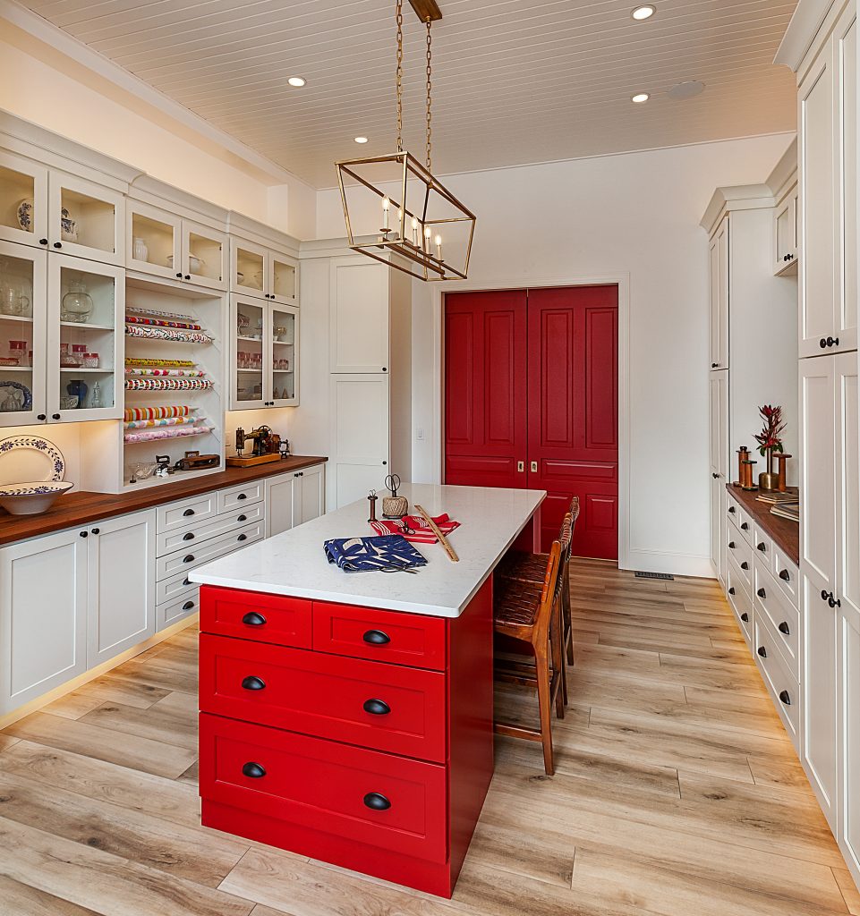 A craft room with a large island space and a gift-wrapping station.