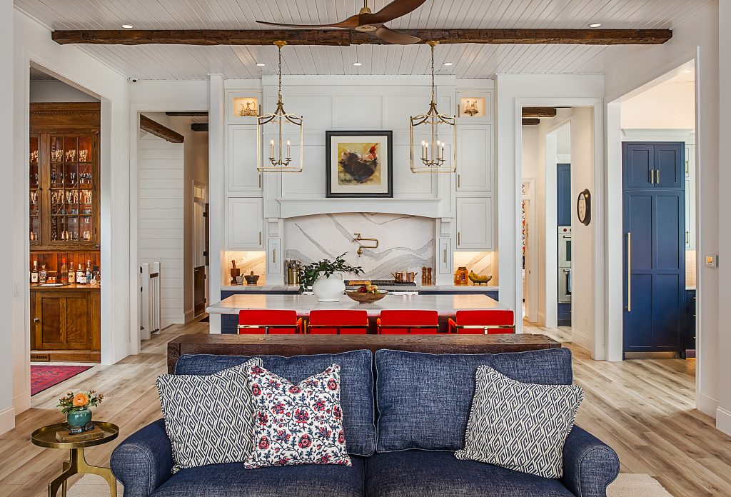 A view from the living room inside a large kitchen space, with an island and seating for four.