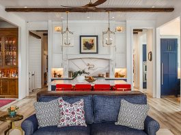 Inside a Gorgeous Waterfront Lenawee County Dream Home by Birch Design Associates A view from the living room inside a large kitchen space, with an island and seating for four.