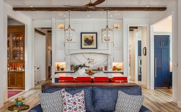 Inside a Gorgeous Waterfront Lenawee County Dream Home by Birch Design Associates A view from the living room inside a large kitchen space, with an island and seating for four.