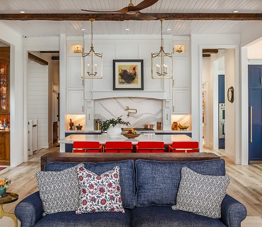 Inside a Gorgeous Waterfront Lenawee County Dream Home by Birch Design Associates A view from the living room inside a large kitchen space, with an island and seating for four.