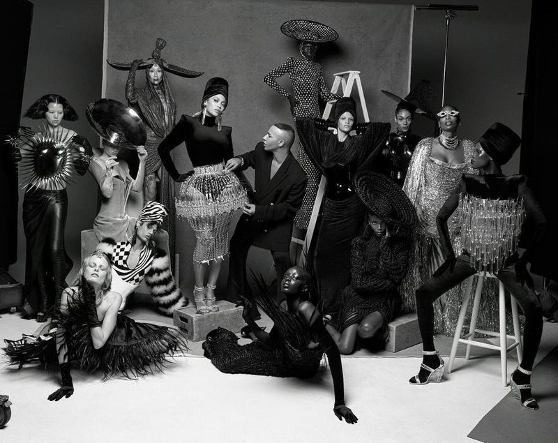 Modeling for the Beyoncé x Balmain Renaissance Couture collection in 2023, Riley (third from right, seated) wears a gown inspired by traditional African hair braiding.