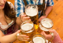 Young couple toasting in Oktoberfest beer tent.