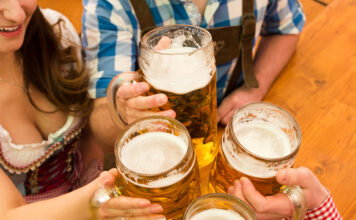 Prost! Celebrating Oktoberfest in Metro Detroit Young couple toasting in Oktoberfest beer tent.