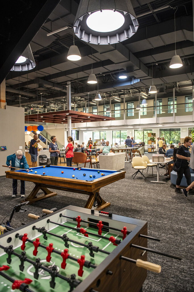 A member shoots pool in the gaming area, which includes foosball, ping pong, and more movement activities.