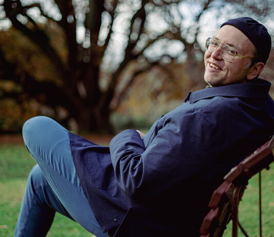 Sam Tallent: The Two-drink Minimum Artist Sam Tallent outdoors, sitting on a chair