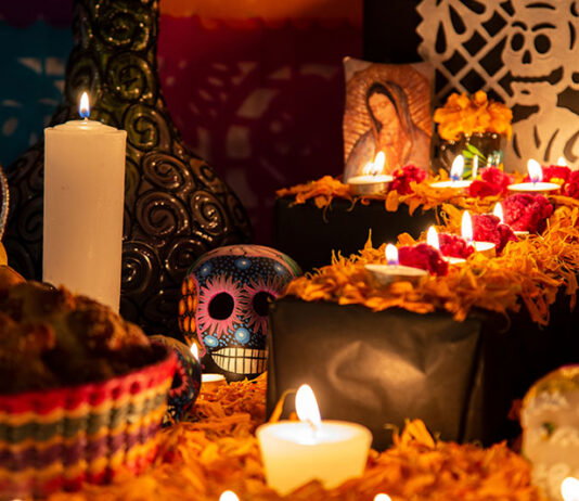 Colorful skull on colorful traditional Day of the Dead "ofrenda"