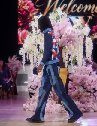 Yvie Styled It's Denim set for men: denim chain-link pattern in blue hues on the pants, and a jacket with light denim trim, stand-up collar, and a colorfully intricate pattern covering the back.